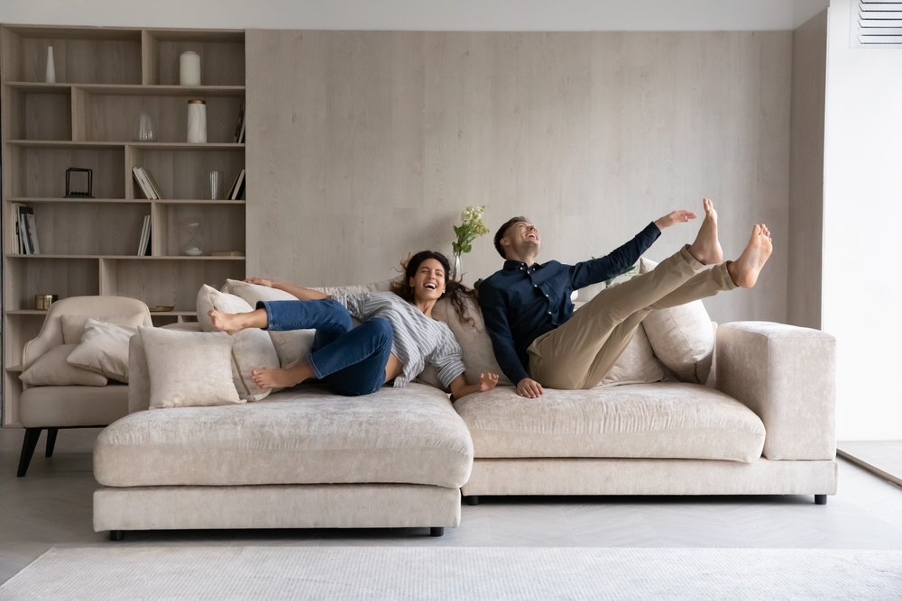 couple laughing and rolling on furniture 