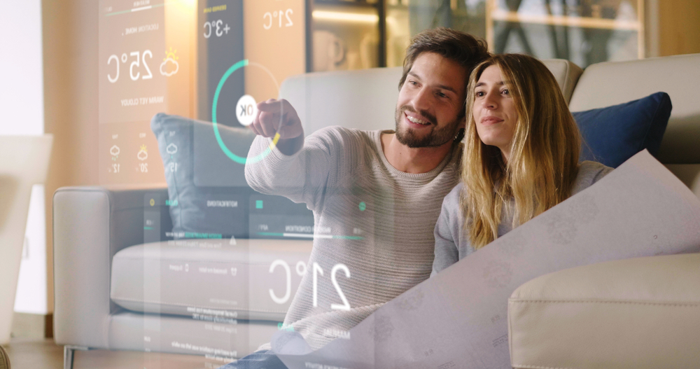 couple from behind a large clear touchscreen pointing to a temperature setting