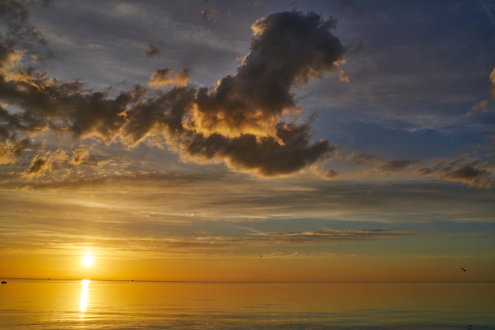 fluctuating FLorida weather shown with clouds and sunshine over the water