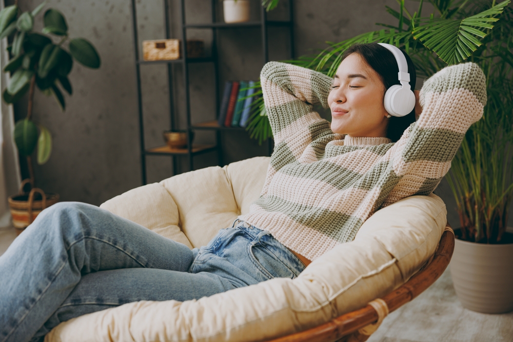 woman, relaxing and listening to music in a comfortable home after a PTU