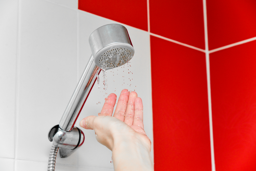 hand testing shower trickle and a home's water pressure