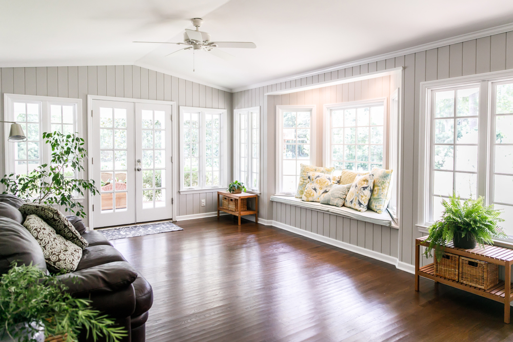 a room withi two walls filled with windows in various sizes 